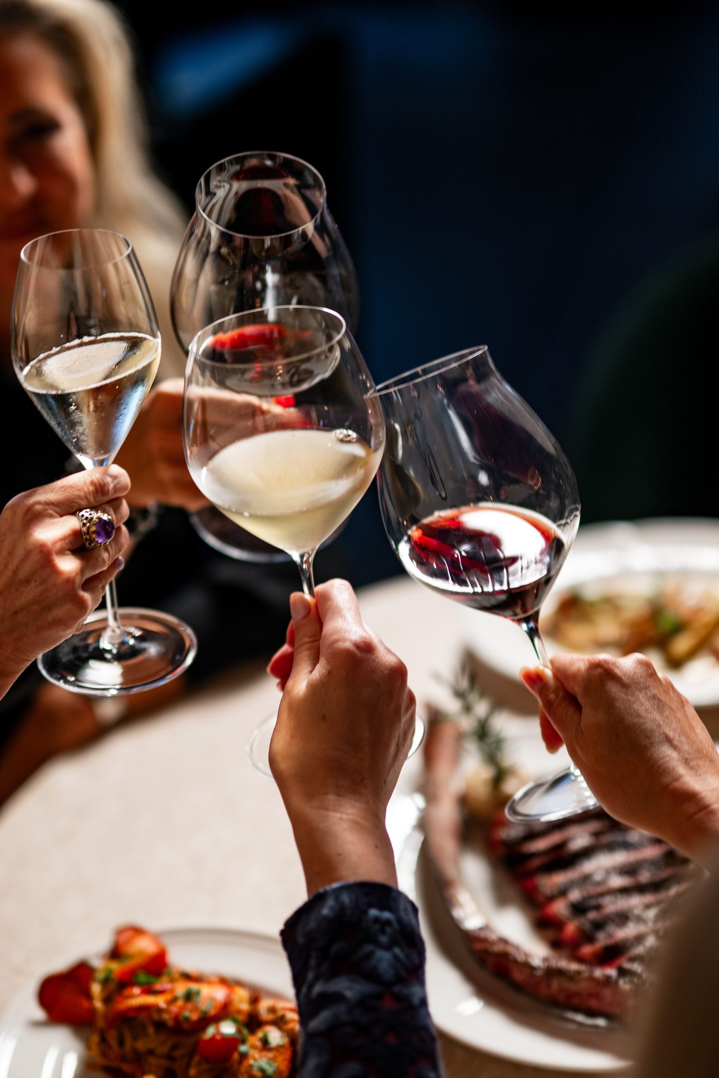 Guests toasting over steak and lobster at Ce Soir Naples