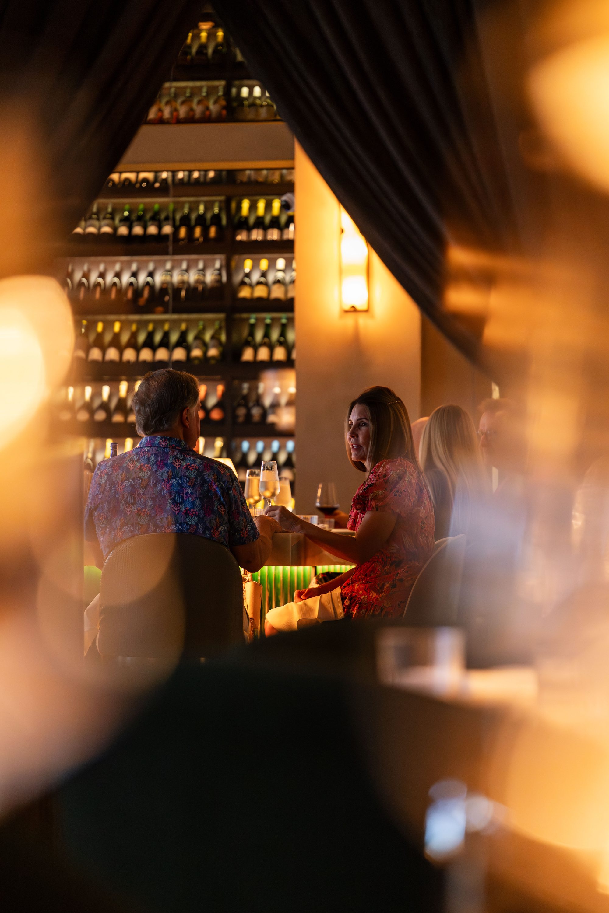 Guests dining by the wine wall at Ce Soir in Naples, Florida