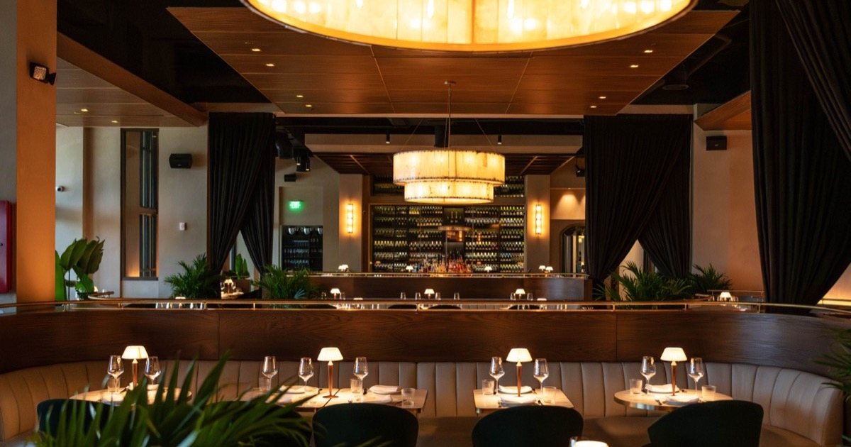 The full dining room and wine wall at Ce Soir Naples, available for private buyouts
